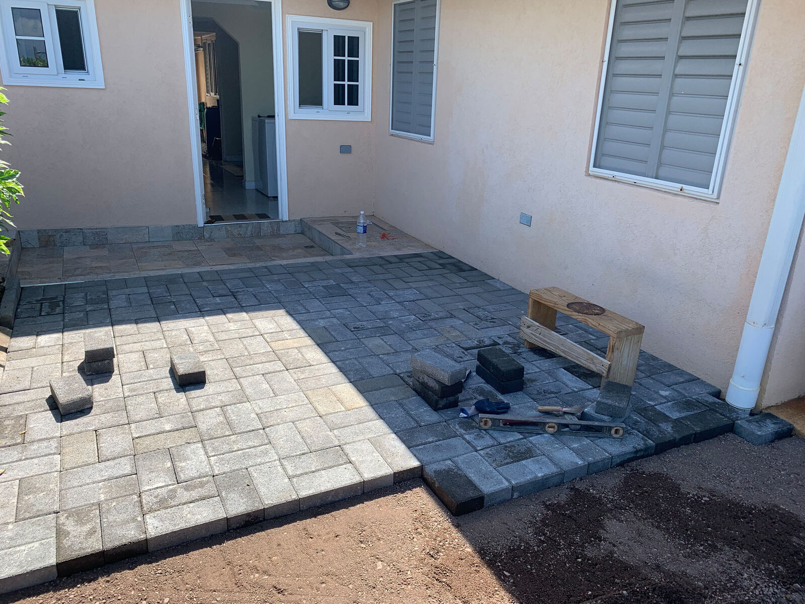 Pavers being installed beside the residence
